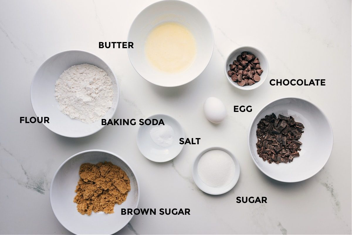 Ingredients prepped for straightforward assembly, including butter, flour, baking soda, chocolate, egg, sugar, and brown sugar.