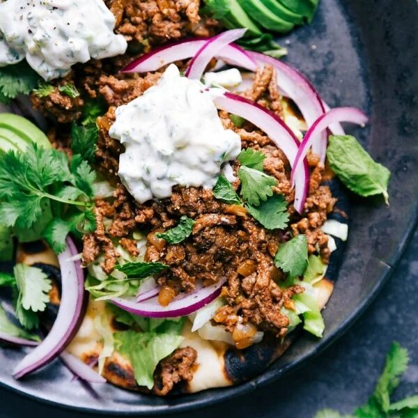 Ground beef naan tacos with all the toppings, a satisfying meal with complimentary flavors ready to be enjoyed.