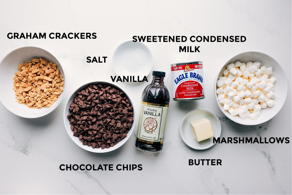 All the ingredients in this recipe prepped out including the graham crackers, chocolate chips, salt, vanilla, sweetened condensed milk, butter, and marshmallows.