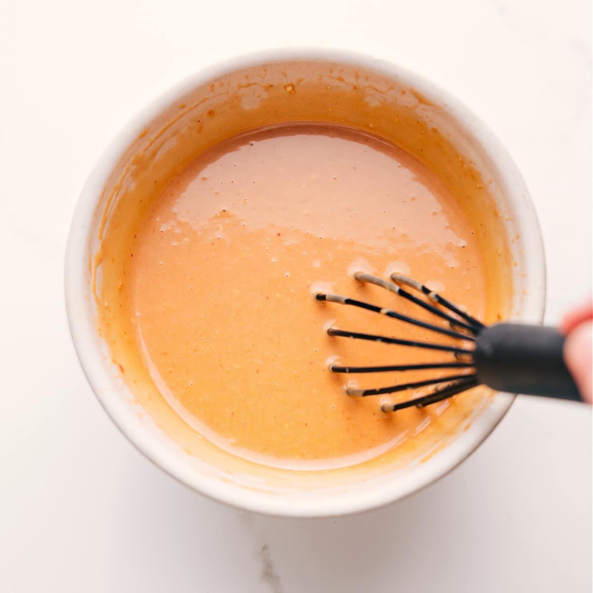 The simple dressing ingredients whisked together in a bowl.