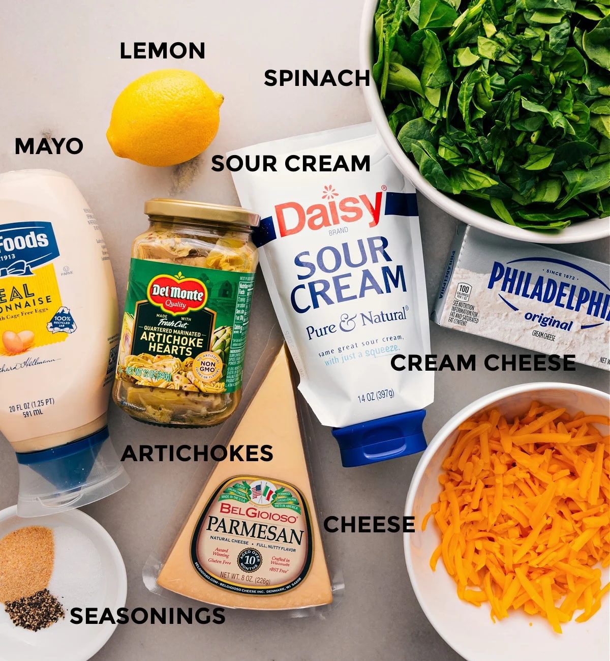 All the ingredients for this recipe are prepped and ready for straightforward assembly: veggies, lemon, cream cheese, mayo, cheese, and seasonings.