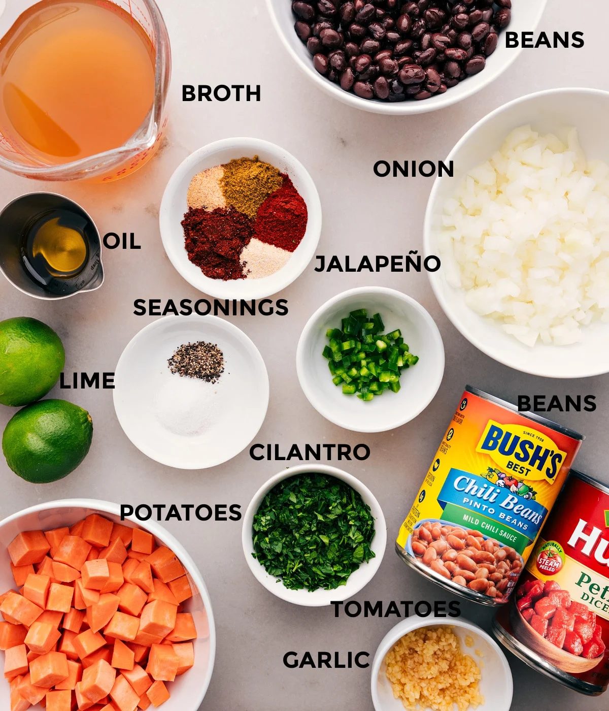 All the ingredients for this recipe—veggies, seasonings, beans, limes, broth, and tomatoes—are prepped and ready for straightforward assembly.