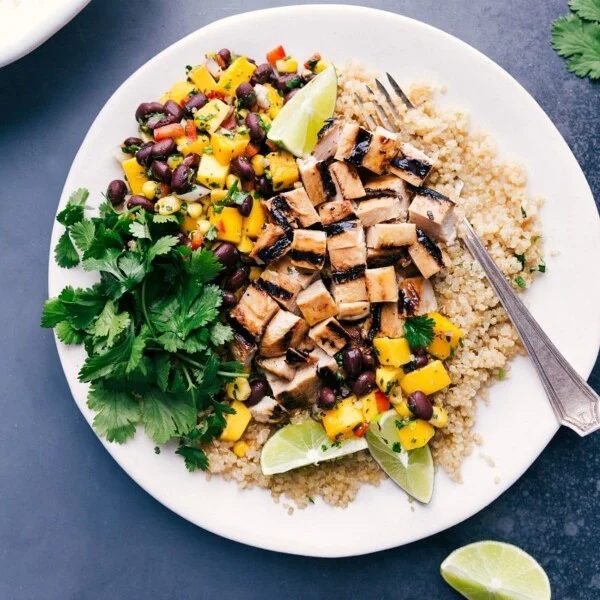 satisfying quinoa chicken bowl with fresh mango salsa and cilantro on the side.