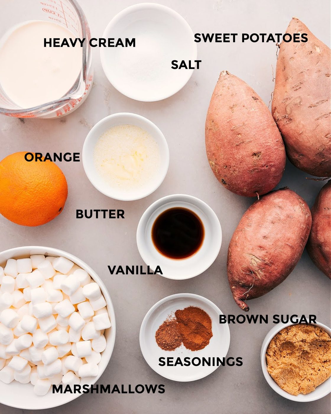 All the ingredients in this recipe prepped out for straightforward assembly including the heavy cream, salt, potatoes, orange, butter, vanilla, seasonings, brown sugar and marshmallows.