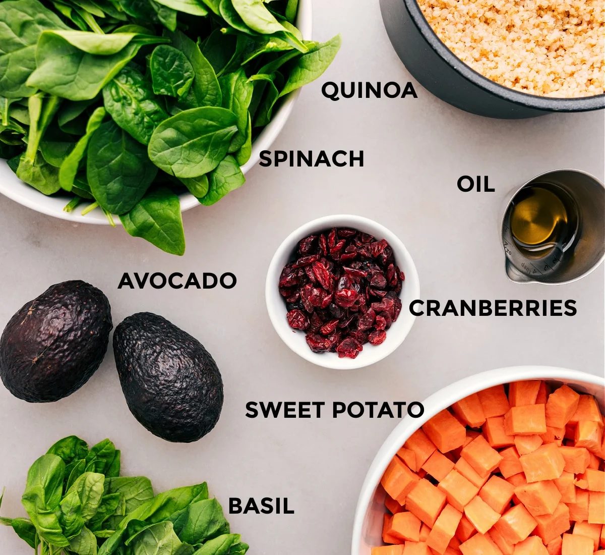 All the ingredients—veggies, grains, cranberries, oil, and avocado—are prepped for straightforward assembly.