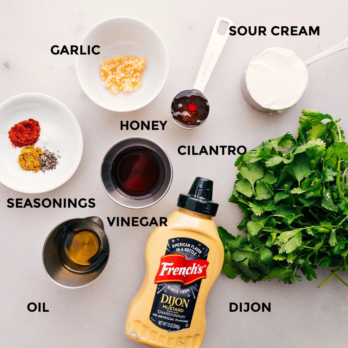 All the dressing ingredients are prepped and ready for straightforward assembly, including honey, vinegar, Dijon, seasoning, sour cream, and garlic for this sweet potato black bean salad.