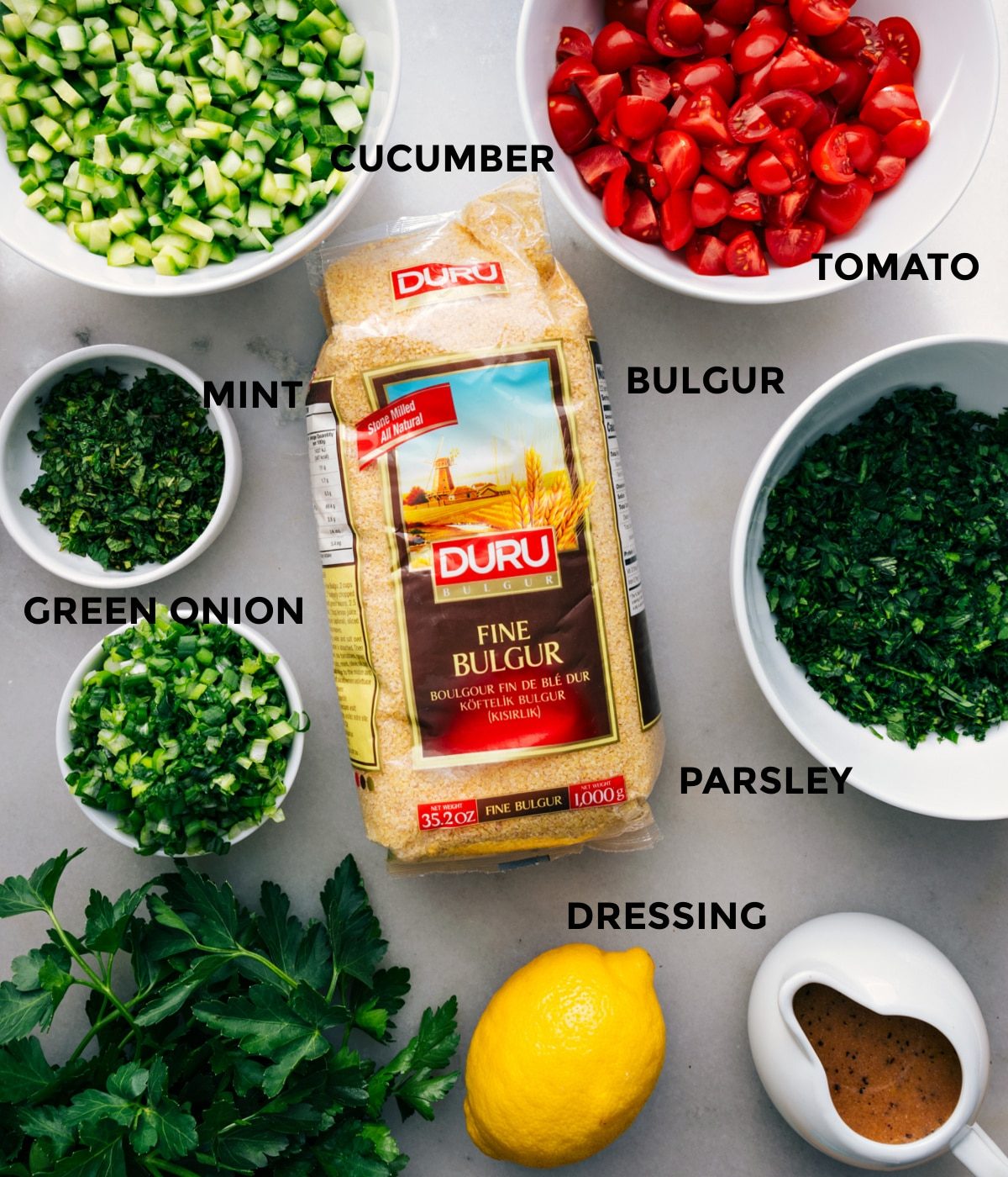 All the ingredients prepped for straightforward assembly: tomato, herbs, cucumber, bulgur, and dressing.