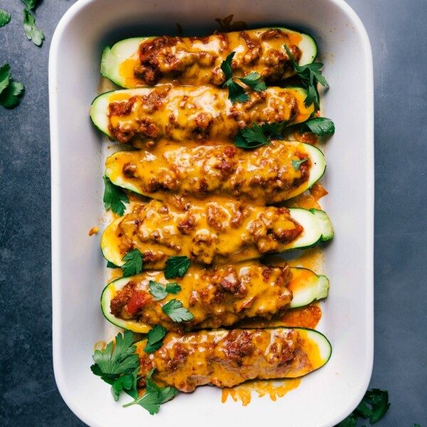Freshly baked zucchini boats, topped with a satisfying meaty sauce and melted cheese, straight out of the oven.