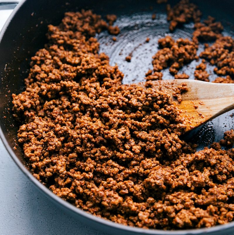 Meat being cooked in a pan with the seasoning blend, absorbing flavors until evenly seasoned.
