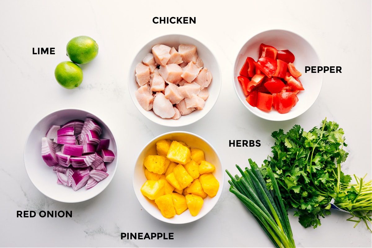 All the ingredient prepped out for straightforward assembly including the limes, red onion, pineapple, chicken, herbs, and pepper.