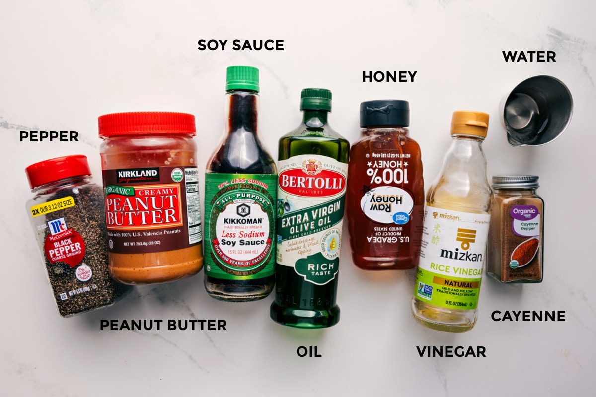 All the ingredients in this recipe prepped out for straightforward assembly including the pepper, peanut butter, soy sauce, oil, honey, vinegar, water, and cayenne.