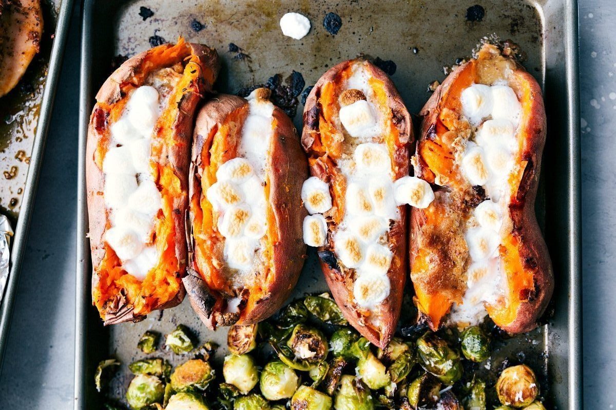 Candied sweet potatoes on a sheet pan with evenly browned marshmallows, ready to serve.