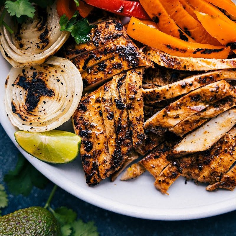 Grilled chicken and fajita veggies on a plate.