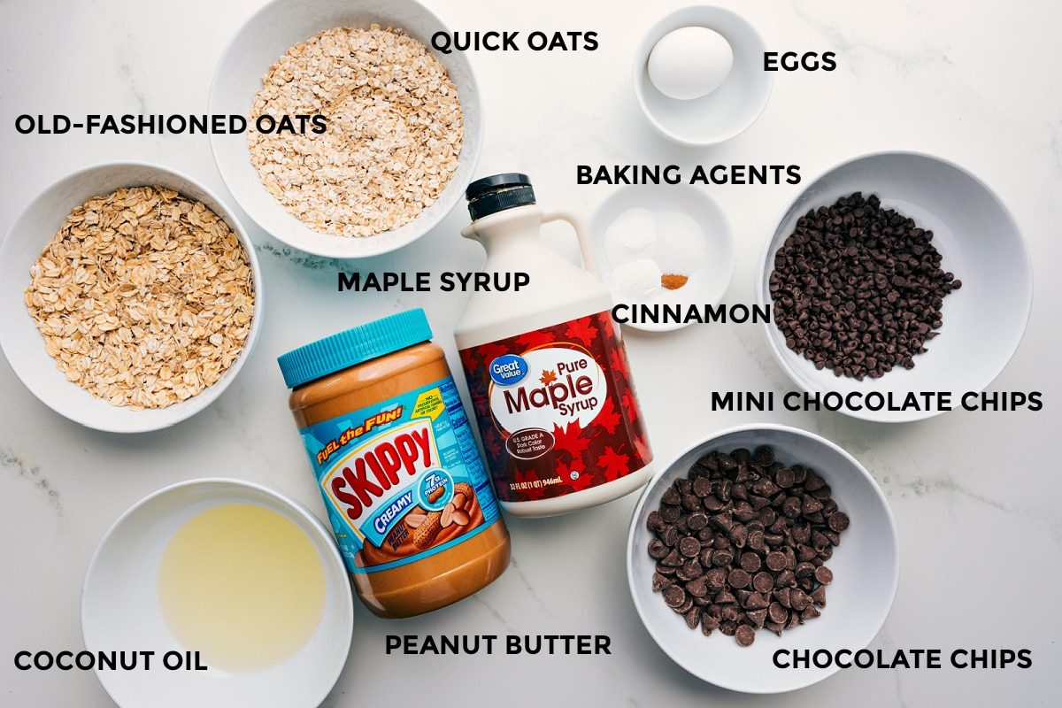 All the ingredients in this recipe prepped out for straightforward assembly including the oats, oil, peanut butter, chocolate, cinnamon, baking agents, and eggs.
