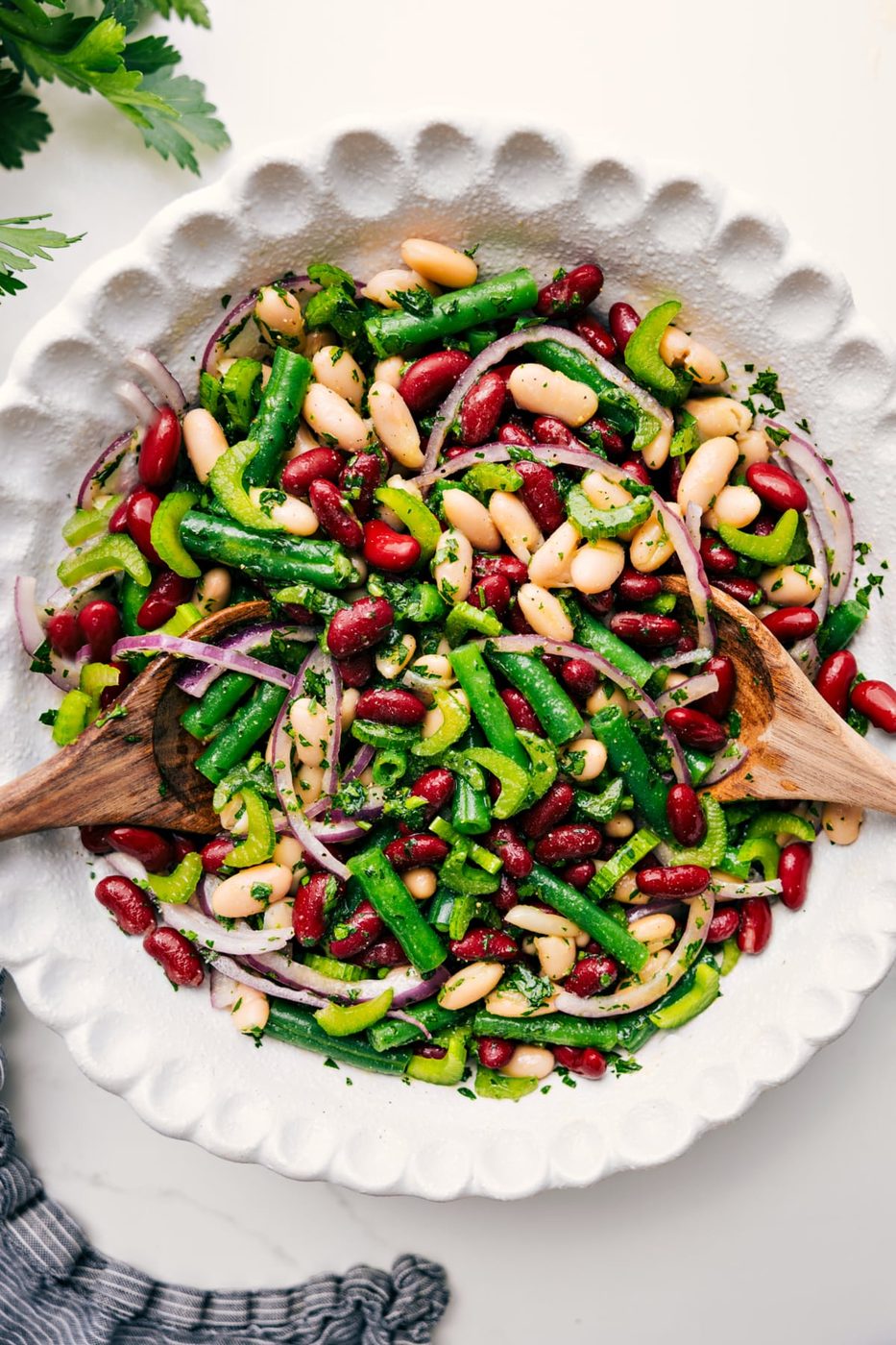 Three bean salad tossed with dressing in a bowl, ready to serve.