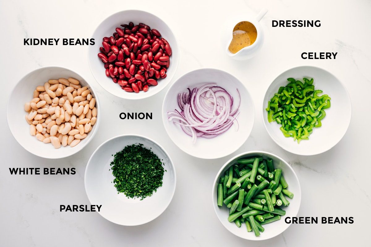 All the ingredients in this recipe prepped out for straightforward assembly including the beans, parsley, onion, green beans, celery, and dressing.