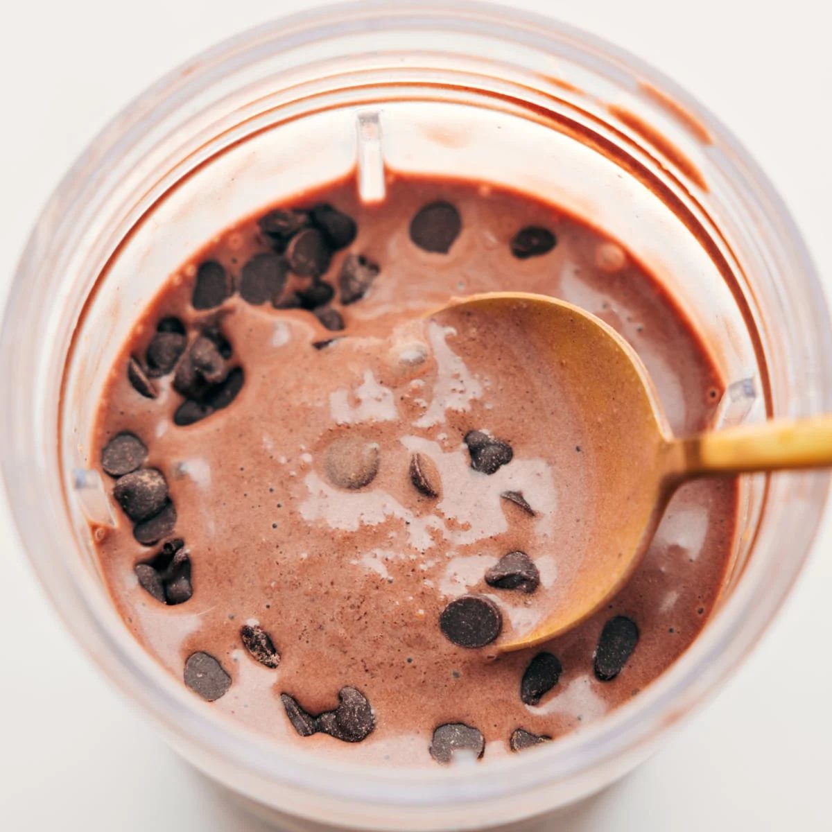 Spoonful of the satisfying and creamy chocolate protein shake with chocolate chips on top for an extra satisfying treat.
