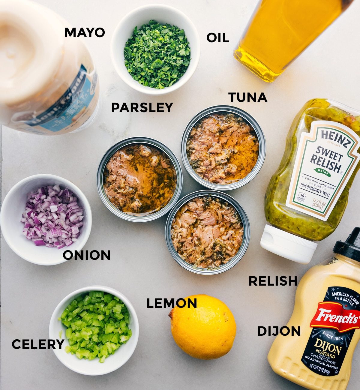 All the ingredients laid out, including mayo, parsley, oil, tuna, onion, relish, lemon, dijon, and celery.