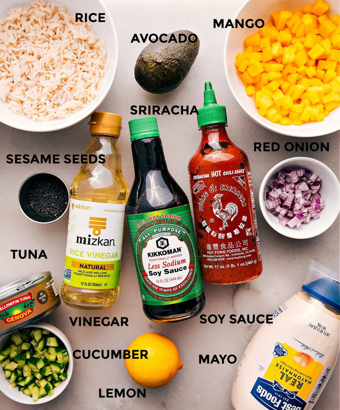 All the ingredients are prepped for straightforward assembly—mango, onion, soy sauce, sriracha, rice vinegar, rice, avocado, sesame seeds, meat, cucumber, mayo, and lemon.