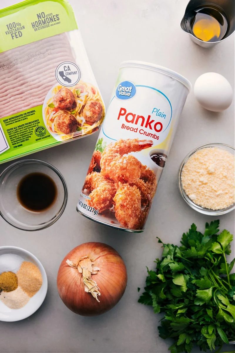 All ingredients for the recipe laid out, including panko, onions, seasonings, meat, and more.