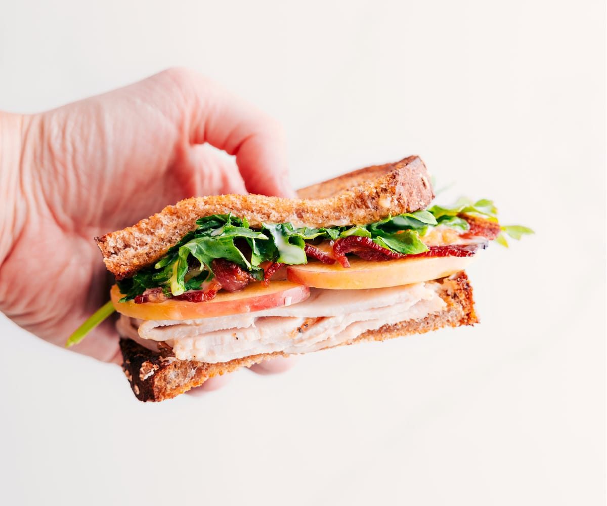 Half of the turkey sandwich held up to show the lively inside.