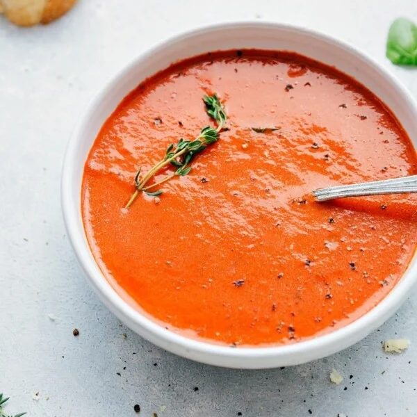 Tomato Basil Soup recipe in a bowl with fresh thyme.