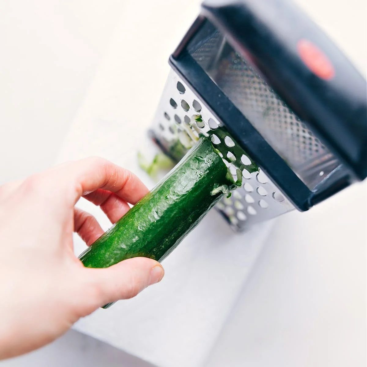 Grating cucumber for this tzatziki sauce recipe.