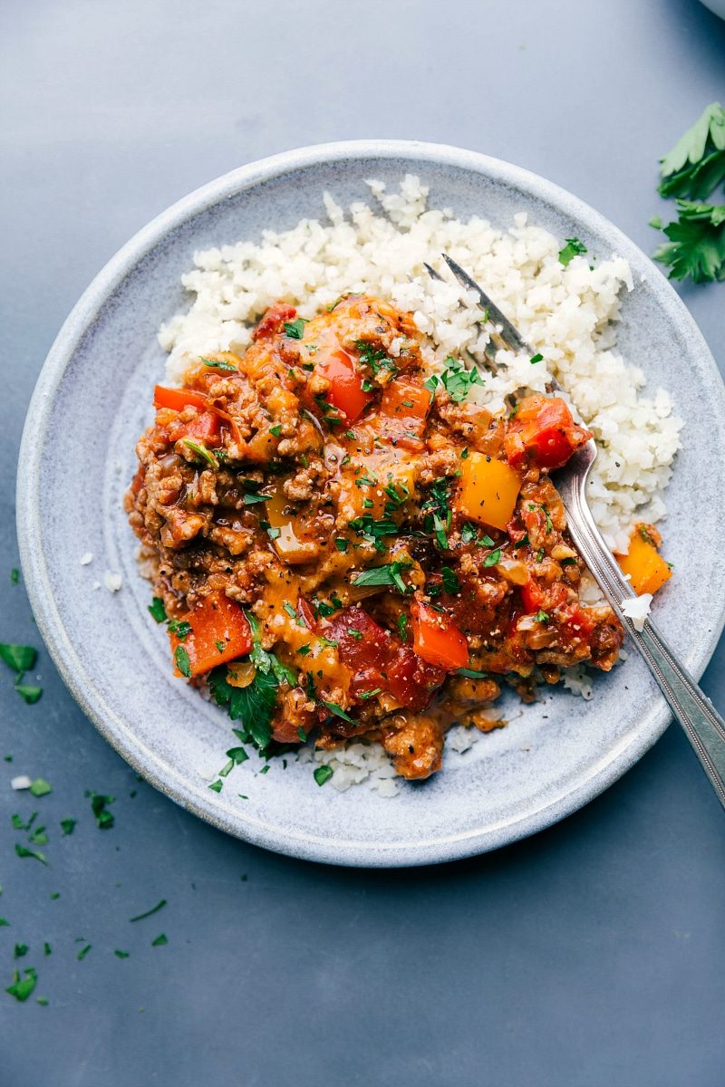 A plate of satisfying and savory unstuffed bell peppers served with cauliflower rice alongside.