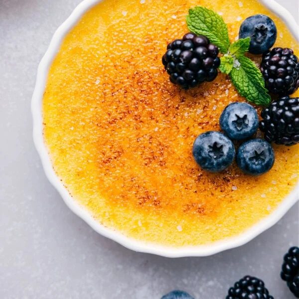 satisfying straightforward creme brûlée with a caramelized top, garnished with fresh fruit.