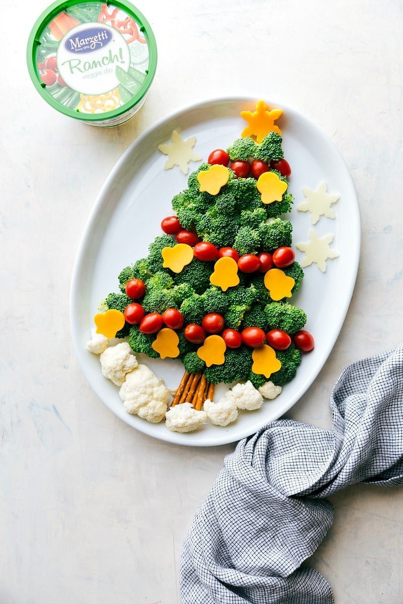 Vegetables arranged in the shape of a Christmas tree with veggie dip for a festive holiday snack.