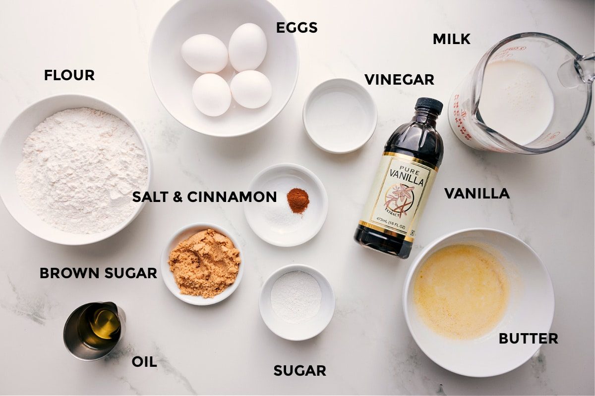 All the ingredients in this recipe prepped out for straightforward assembly including the flour, brown sugar, oil, eggs, salt, cinnamon, vinegar, sugar, vanilla, milk, and butter.