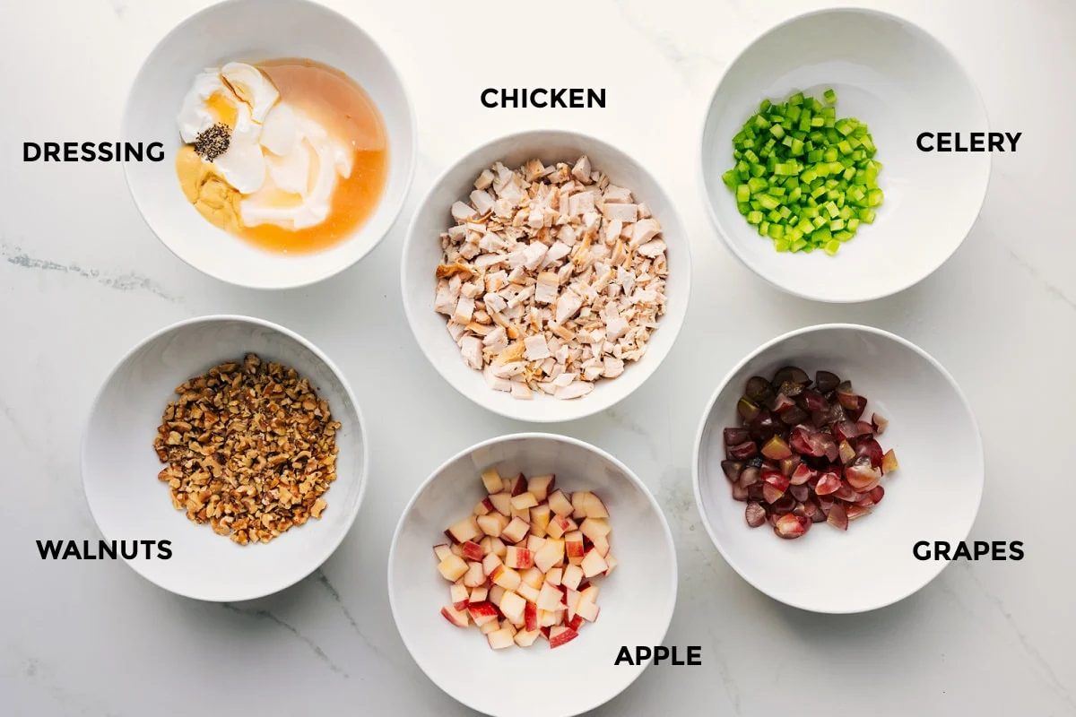All the ingredients prepped out for straightforward assembly including the dressing, walnuts, apple, chicken, grapes, and celery.