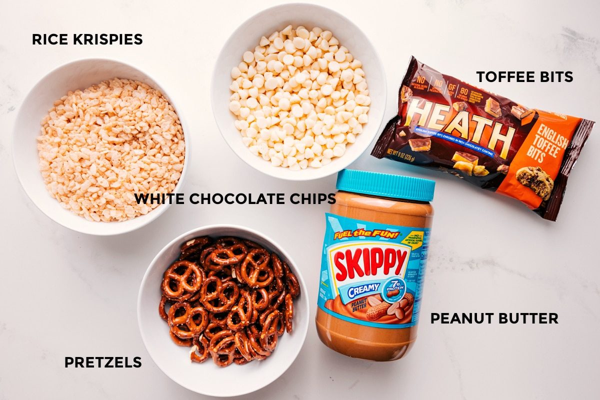All the ingredients in this recipe prepped out for straightforward assembly including the rice krispies, pretzels, white chocolate chips, peanut butter, and toffee bits.