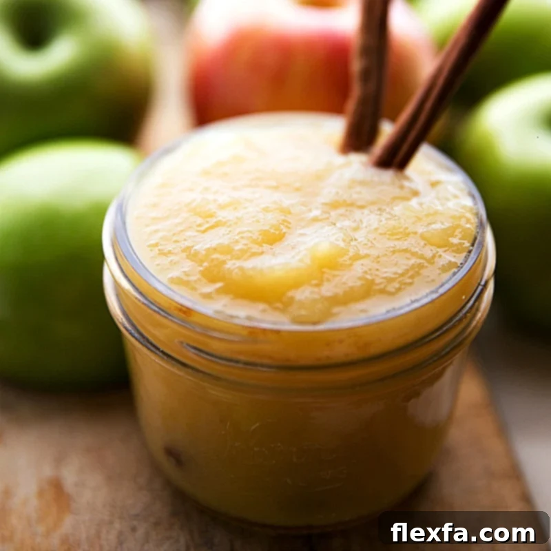 Fresh applesauce in a glass container, prominently featured as a key ingredient for a delightful applesauce cake recipe.
