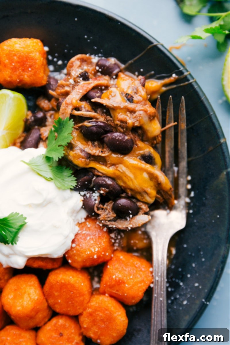 Deconstructed Beef Totchos are a delicious and easy one-sheet pan meal with less than 10 ingredients. Recipe via ChelseasMessyApron #dinner #quick #easy #simple #best #30mins #avocado #cheese #tatertots #sweetpotato #deconstructed #beef #totchos Deconstructed Beef Totchos ready to eat with various toppings