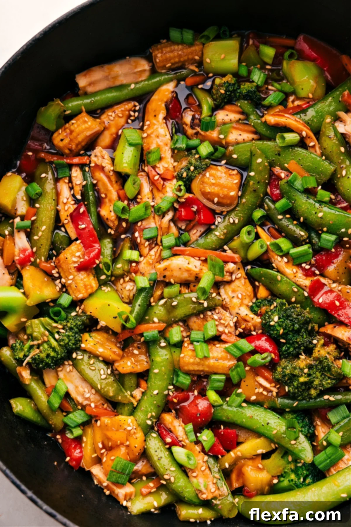 30-Minute One Skillet Rotisserie Chicken Stir Fry The finished rotisserie chicken stir-fry, glistening with its savory sauce, served directly from the skillet and ready for enjoyment.