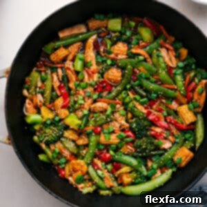 A close-up shot of Rotisserie Chicken Stir-Fry in a wok, showing the rich sauce, tender chicken, and colorful vegetables.