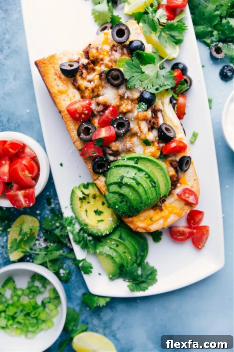 Delicious French Bread Taco Pizza, loaded with taco meat, melted cheese, and fresh toppings.