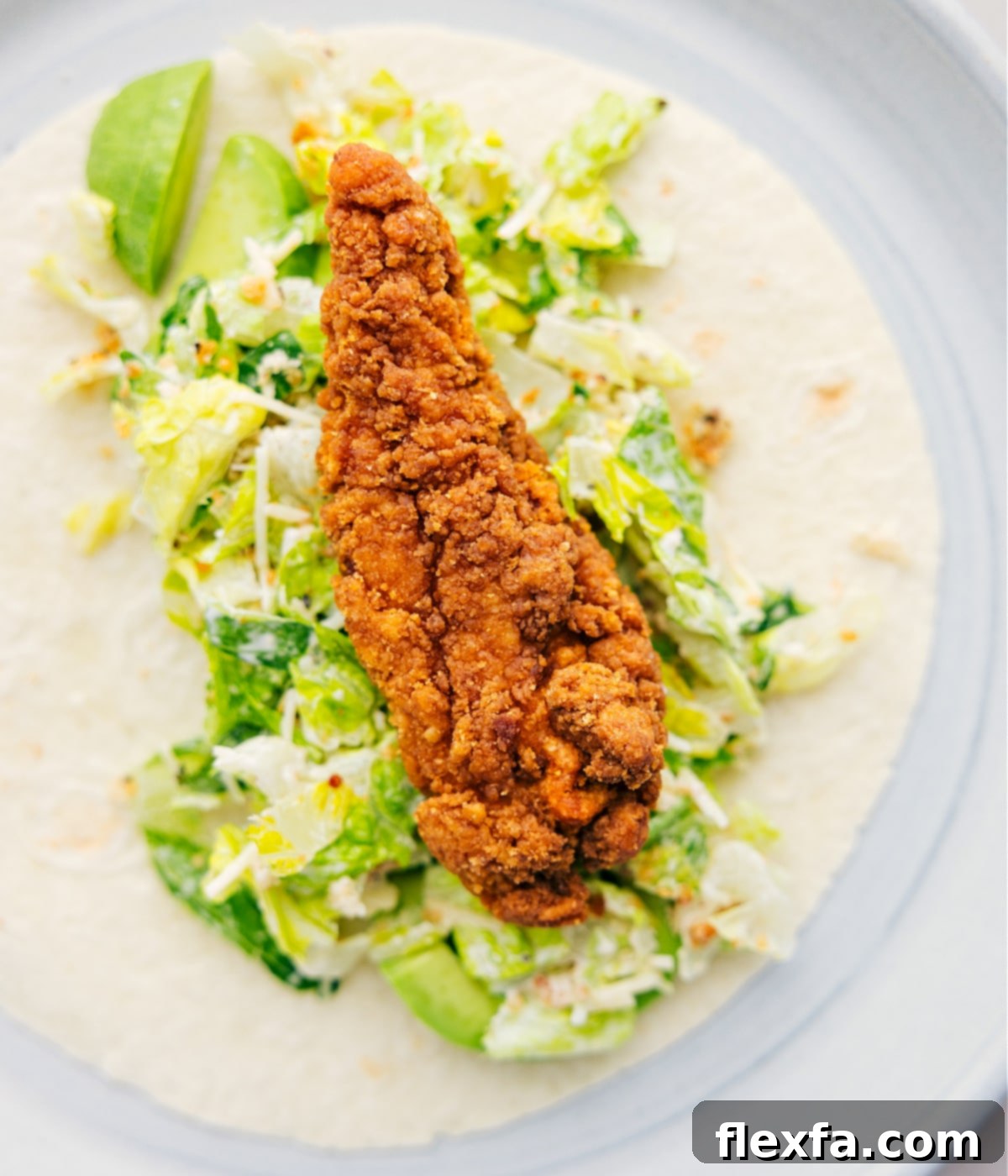 The step-by-step process of filling a tortilla with salad, chicken, and avocado, illustrating how to assemble the Chicken Caesar Wrap for a satisfying lunch.