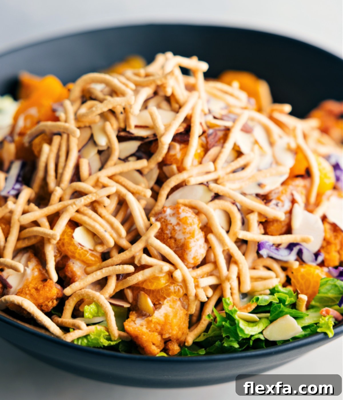 The Applebee's Chicken Salad, beautifully tossed together in a large bowl, prominently featuring the delightful crunch of crispy chow mein noodles.