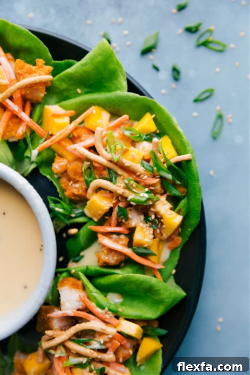Fresh Asian Chicken Lettuce Wraps served on a white plate with a side of dressing