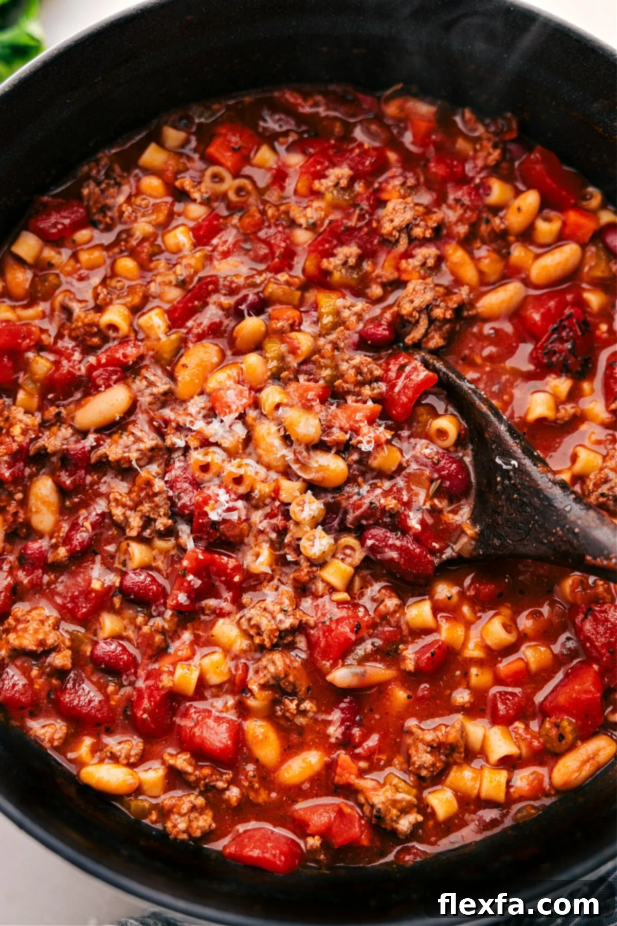 The Best Olive Garden Copycat Pasta E Fagioli Recipe A steaming bowl of homemade Olive Garden Pasta e Fagioli soup, garnished with fresh herbs and Parmesan cheese, ready to be enjoyed.