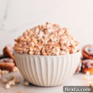 A close-up shot of Cinnamon Roll Popcorn in a serving bowl, showcasing its delicious layers of caramel, white chocolate, and cinnamon sugar.