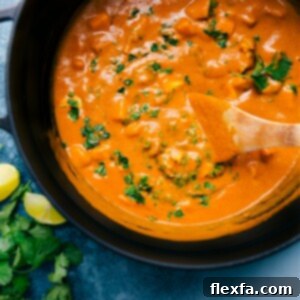 A serving of rich Mango Chicken Curry garnished with fresh cilantro.