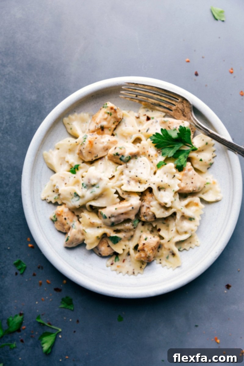 Delicious and creamy chicken alfredo on a plate, ready to be enjoyed, garnished with fresh parsley.
