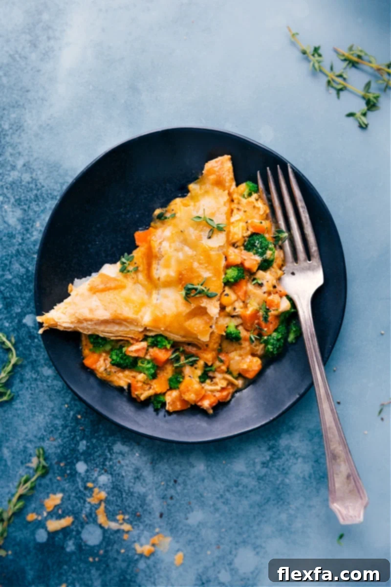 Broccoli Cheddar Pot Pie: cheesy broccoli, seasoned chicken, tender carrots, and a buttery, flaky puff pastry crust. #dinner #quick #easy #simple #comfortfood #best #kidfriendly #familyfriendly #broccoli #cheddar #potpie Golden brown Broccoli Cheddar Pot Pie with a flaky puff pastry crust, brimming with cheesy broccoli, chicken, and carrots.