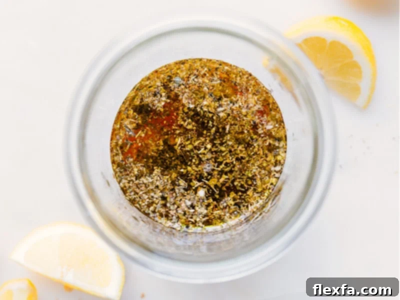 Close-up process shots of individual ingredients, including olive oil, lemon, honey, and herbs, being added to a clear glass jar, demonstrating the simple preparation of Greek Salad Dressing step-by-step.