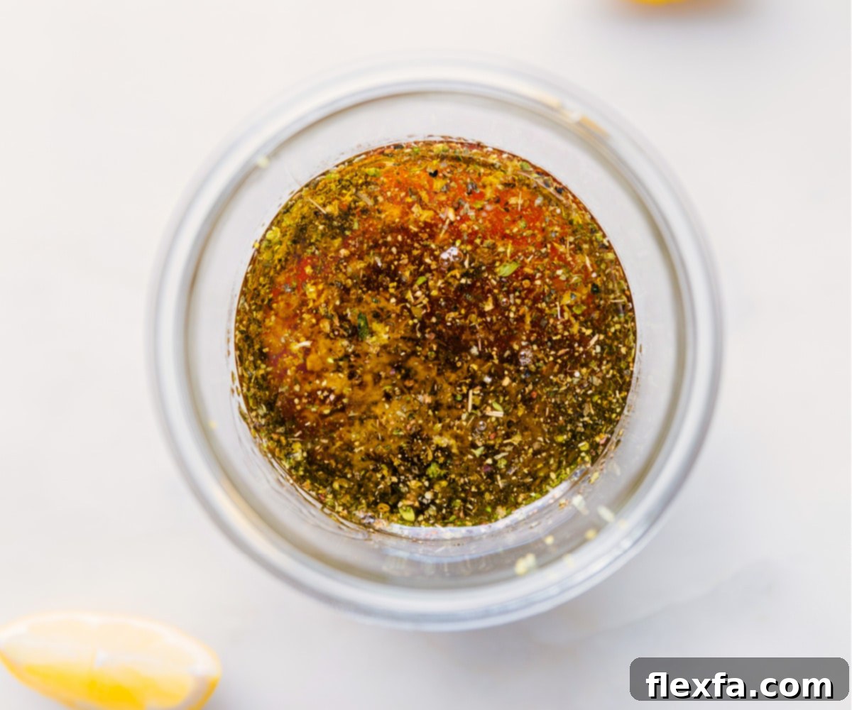 All the vibrant ingredients for Lemon Vinaigrette, including fresh lemons, olive oil, and honey, are added to a mason jar, ready for mixing.