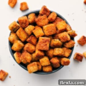 Close-up of golden homemade croutons in a bowl, showing their crispy texture.