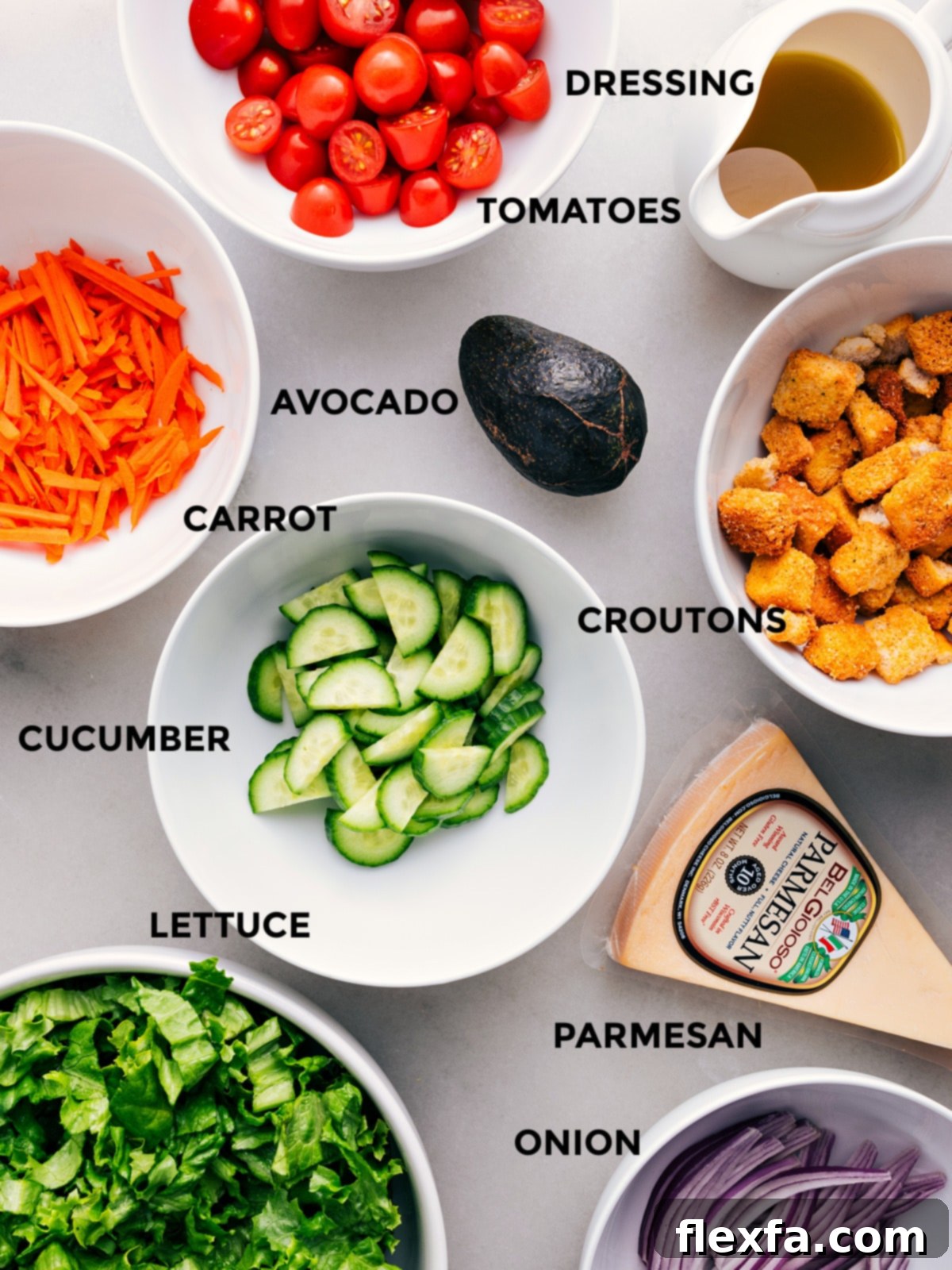 Key Ingredients for Your Homemade Garden Salad A selection of fresh garden salad ingredients prepped and arranged: creamy avocado, vibrant romaine lettuce, shredded Parmesan, crunchy croutons, sliced cucumbers, juicy cherry tomatoes, and a small bowl of homemade dressing.
